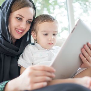 Beautiful Arabic family, mother and cute baby with tablet